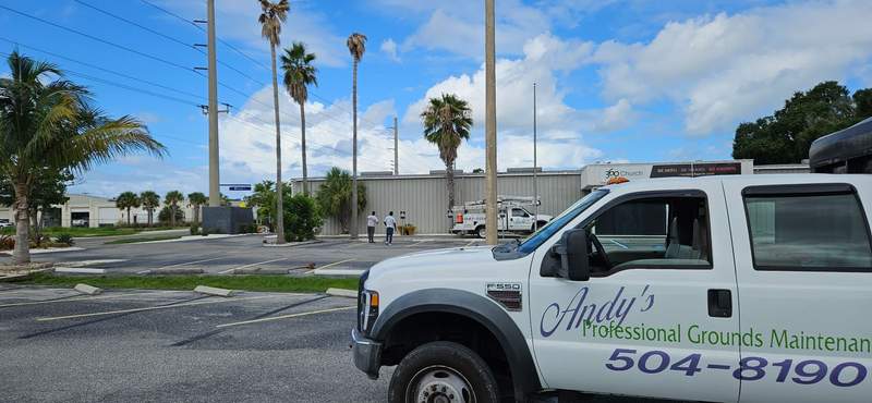White Andy's Professional Grounds Maintenance truck with 504-8190 lettered on the door.